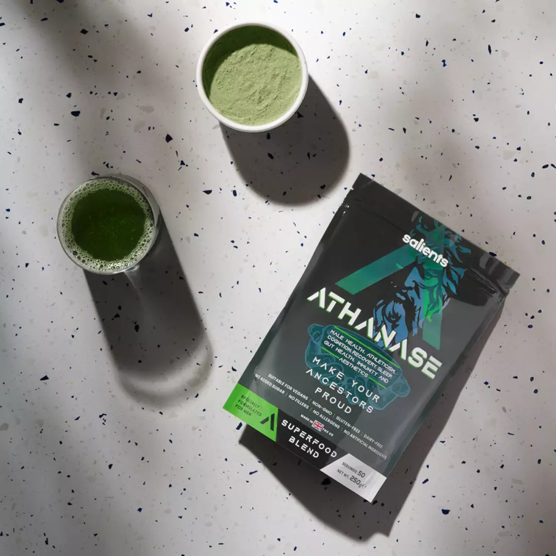 Athanasia superfood blend packaging with two glasses of green powder on a speckled surface