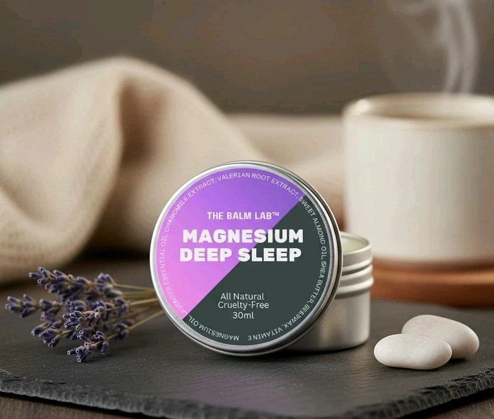 Tin of 'Magnesium Deep Sleep' from The Balm Lab on a dark surface with lavender and stones.