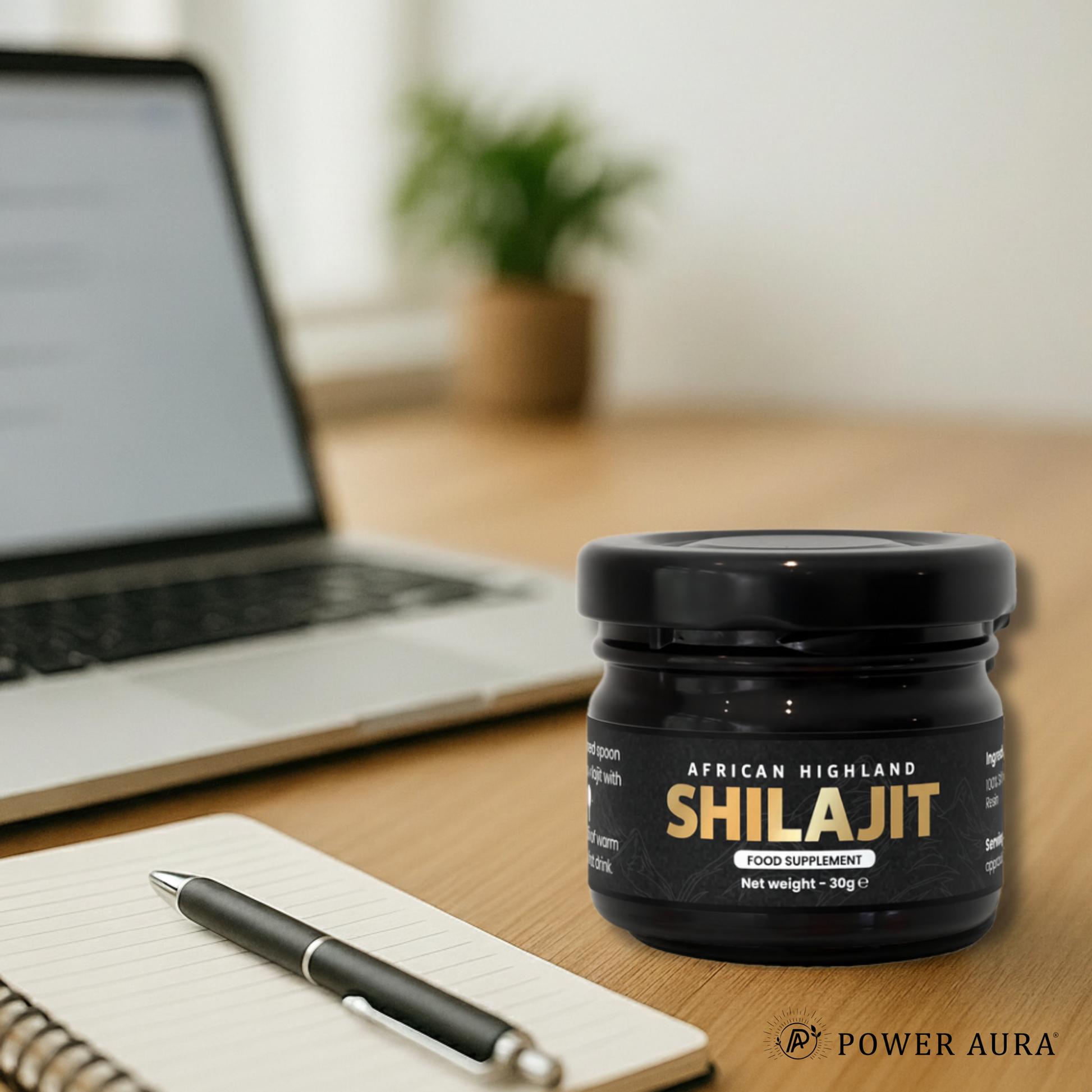 Jar of African Highland Shilajit on a desk with a laptop and notebook in the background